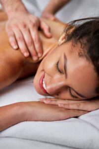 Close-up of happy woman with eyes closed enjoying in back massage at the spa.